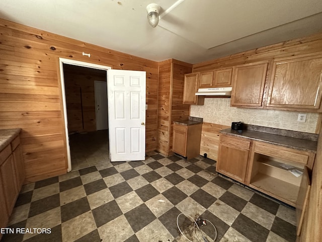 921 Winchester Ave, Middlesboro, KY 40965 - kitchen with under cabinet range hood, wooden walls, dark countertops, and dark floors