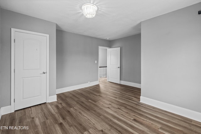spare room with wood finished floors and baseboards