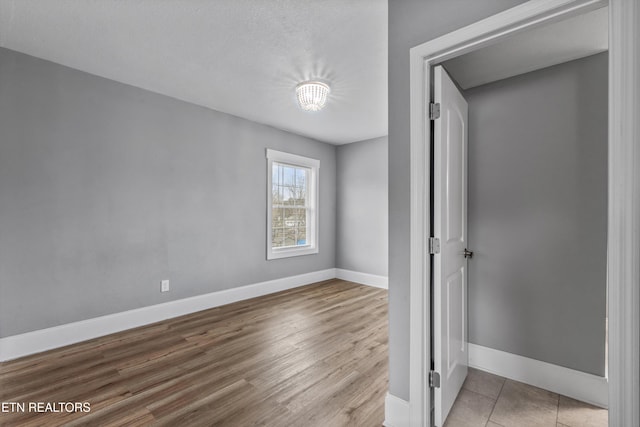 unfurnished bedroom featuring baseboards and wood finished floors