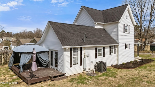 rear view of house with french doors, roof with shingles, central AC, and a deck