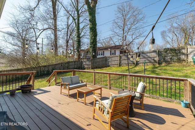 wooden terrace with an outdoor living space with a fire pit and a fenced backyard