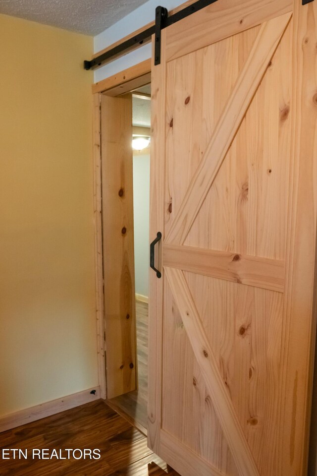 4662 Baker Hwy, Huntsville, TN 37756 - interior space with baseboards, a textured ceiling, a barn door, and wood finished floors