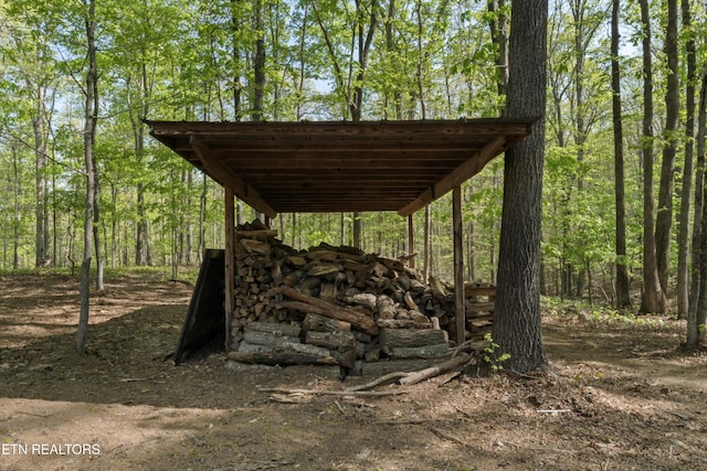 view of parking featuring a wooded view