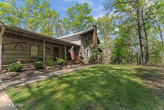 view of side of property featuring a lawn and a chimney