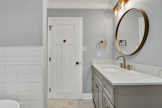 bathroom with vanity, crown molding, and wood finished floors