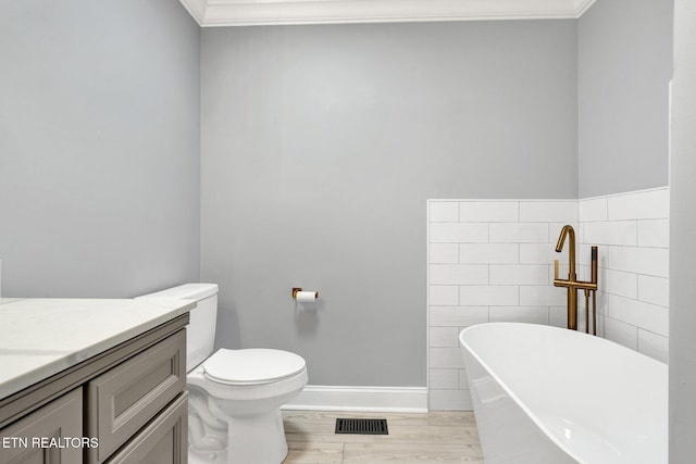 full bathroom with visible vents, ornamental molding, a freestanding tub, wood finished floors, and vanity