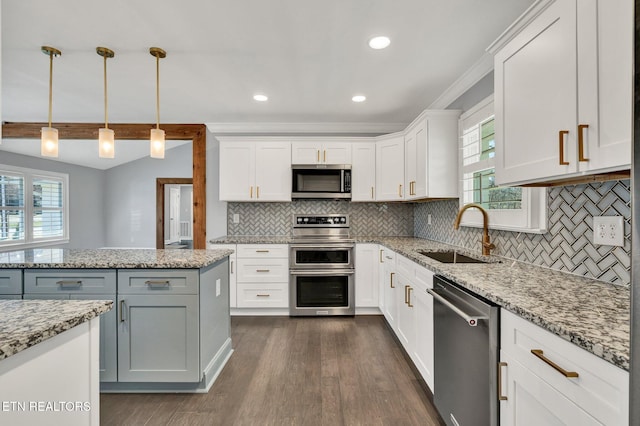 kitchen with tasteful backsplash, dark wood-type flooring, appliances with stainless steel finishes, white cabinets, and a sink