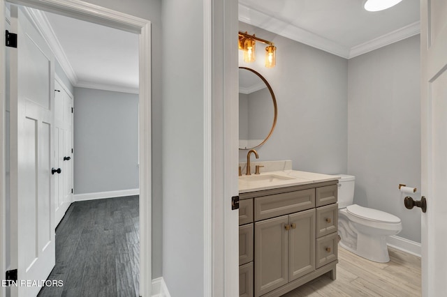 bathroom featuring vanity, toilet, crown molding, and wood finished floors