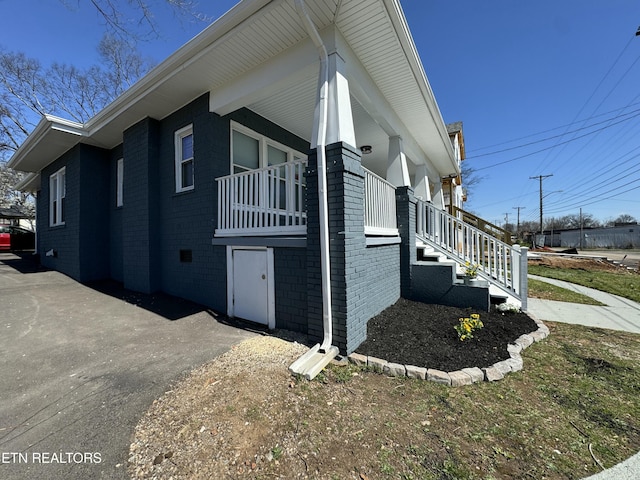 view of property exterior with brick siding and stairs