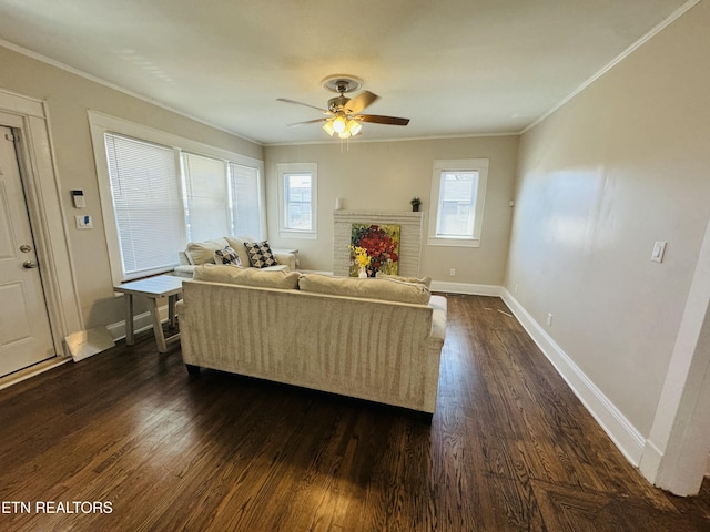 living room featuring dark wood-type flooring, ornamental molding, baseboards, and ceiling fan