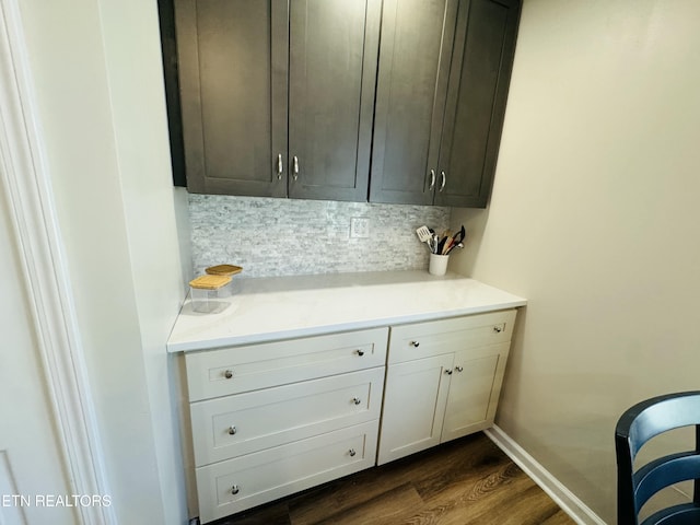 interior space featuring dark wood-style floors, tasteful backsplash, and baseboards