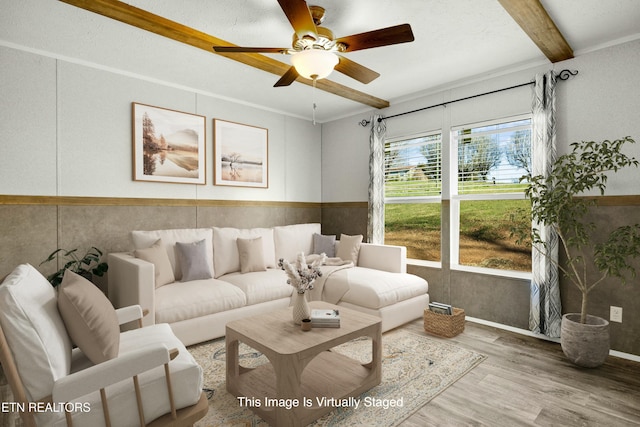 living room with ceiling fan, beam ceiling, and wood finished floors
