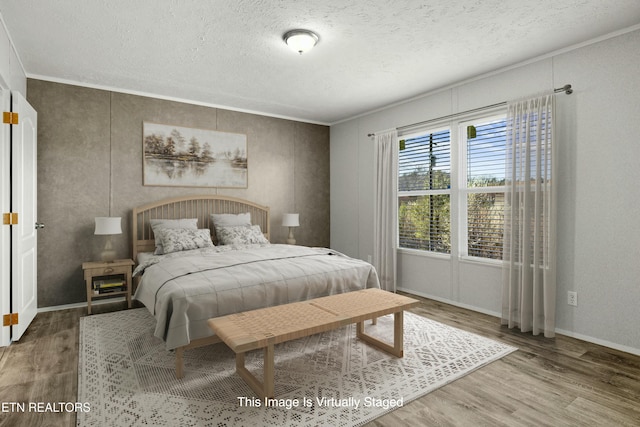 bedroom featuring a textured ceiling, crown molding, and wood finished floors