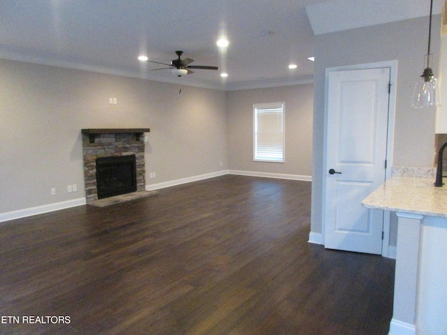 unfurnished living room featuring dark wood finished floors, baseboards, and a ceiling fan