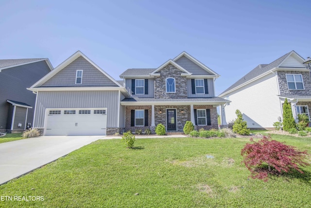 craftsman-style home with stone siding, covered porch, a garage, concrete driveway, and a front lawn