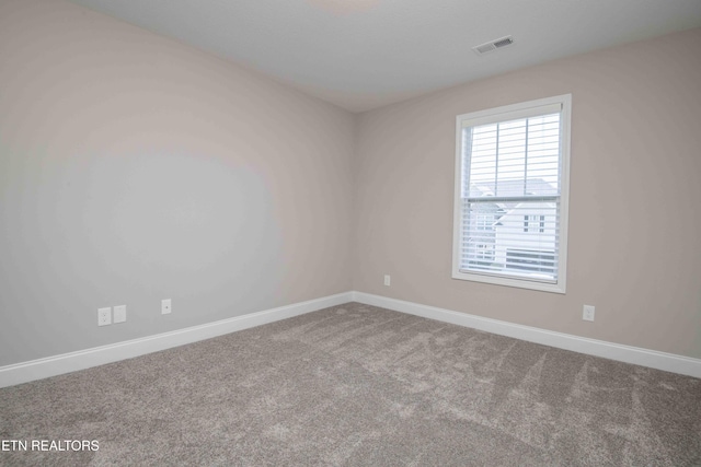 empty room with baseboards, visible vents, and carpet floors