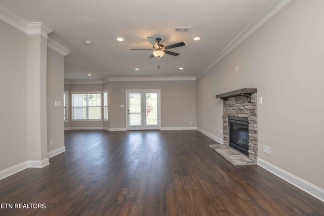 unfurnished living room with visible vents, a stone fireplace, a ceiling fan, dark wood finished floors, and crown molding