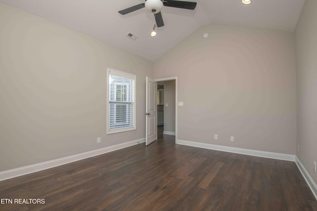 empty room featuring dark wood-type flooring, visible vents, vaulted ceiling, and ceiling fan