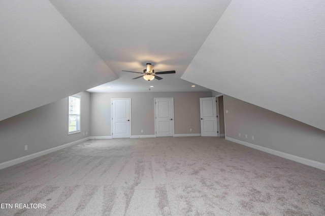 additional living space with carpet, baseboards, a ceiling fan, and lofted ceiling