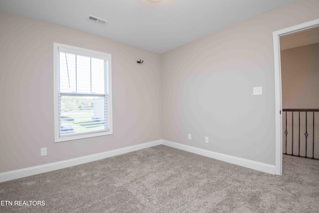 carpeted empty room with visible vents and baseboards