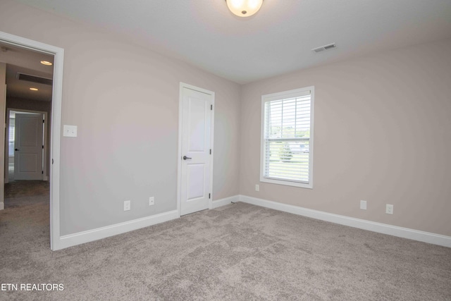 carpeted spare room with baseboards and visible vents