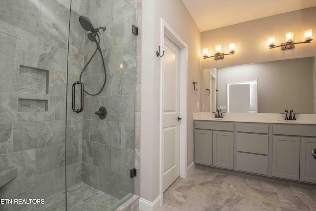 bathroom with double vanity, baseboards, a sink, and a stall shower
