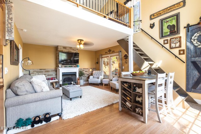 1027 N Highland Dr, Gatlinburg, TN 37738 - living area featuring stairway, a ceiling fan, a fireplace, a high ceiling, and wood finished floors
