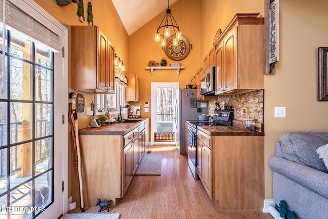 1027 N Highland Dr, Gatlinburg, TN 37738 - kitchen featuring a notable chandelier, a sink, tasteful backsplash, stainless steel appliances, and light wood-style floors