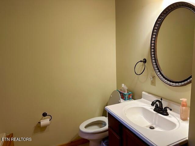 half bathroom with vanity and toilet