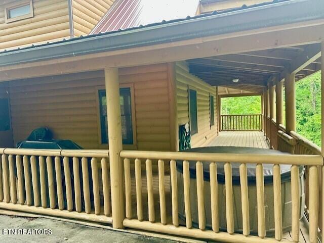 exterior space with a porch and faux log siding