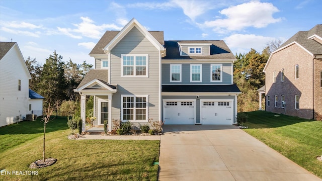 view of front of home featuring a front yard, driveway, an attached garage, central AC, and a shingled roof