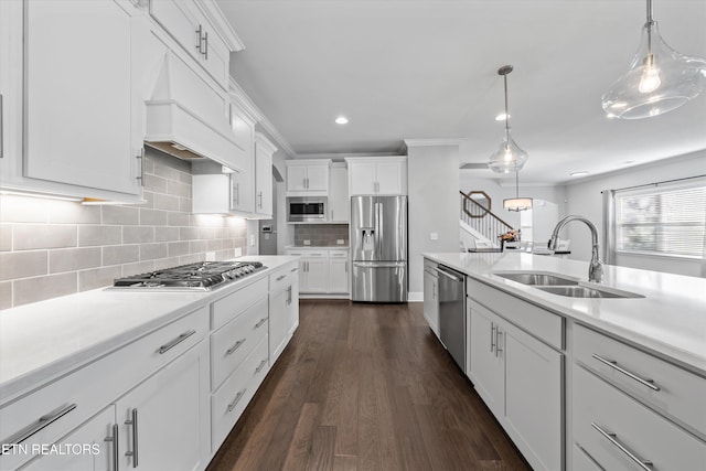 kitchen featuring dark wood finished floors, light countertops, appliances with stainless steel finishes, white cabinetry, and a sink
