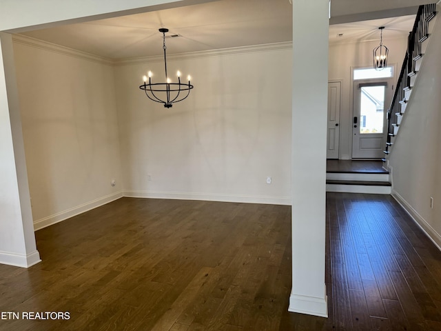 unfurnished dining area featuring an inviting chandelier, crown molding, baseboards, and dark wood-type flooring