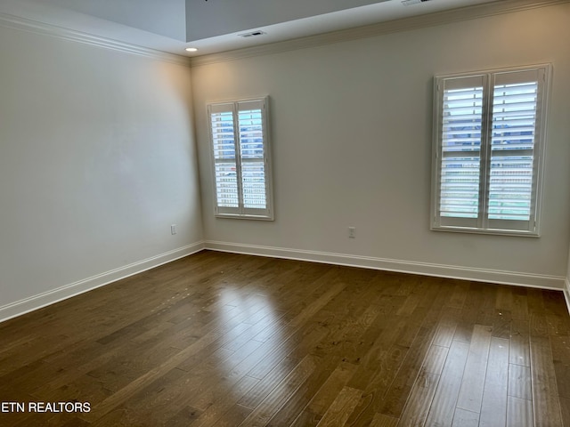 unfurnished room with visible vents, ornamental molding, baseboards, and dark wood finished floors
