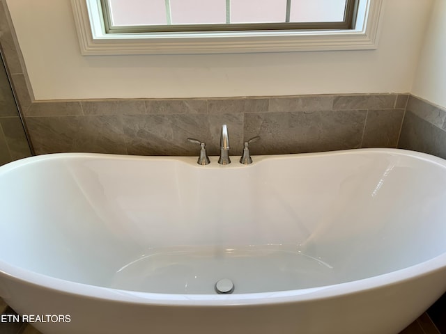 full bath featuring a freestanding tub
