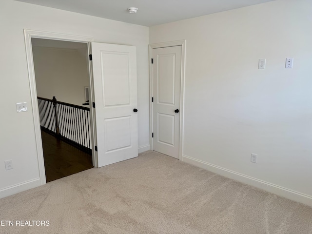 unfurnished bedroom featuring carpet and baseboards