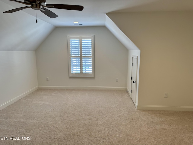 bonus room with baseboards, lofted ceiling, a ceiling fan, and light carpet