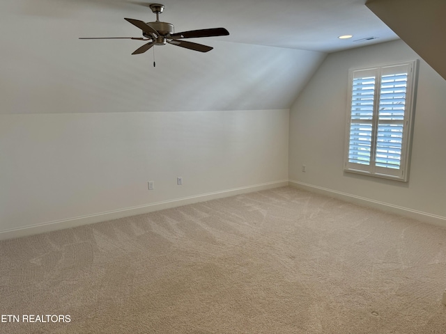 bonus room featuring lofted ceiling, baseboards, light colored carpet, visible vents, and ceiling fan