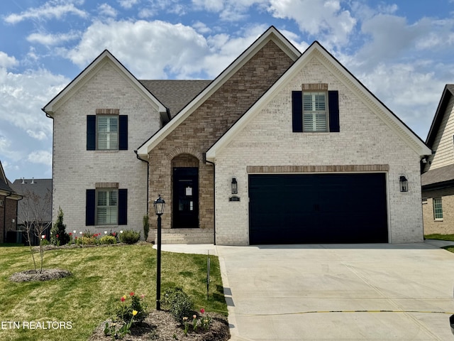 french provincial home with brick siding, driveway, and a front lawn
