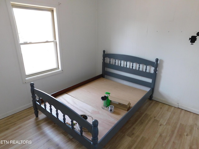 bedroom with wood finished floors and baseboards