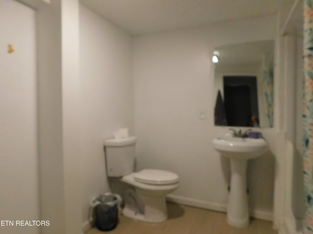 full bathroom featuring a shower with curtain, toilet, and wood finished floors