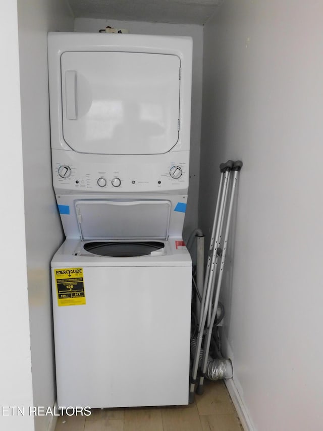 clothes washing area with laundry area and stacked washing maching and dryer