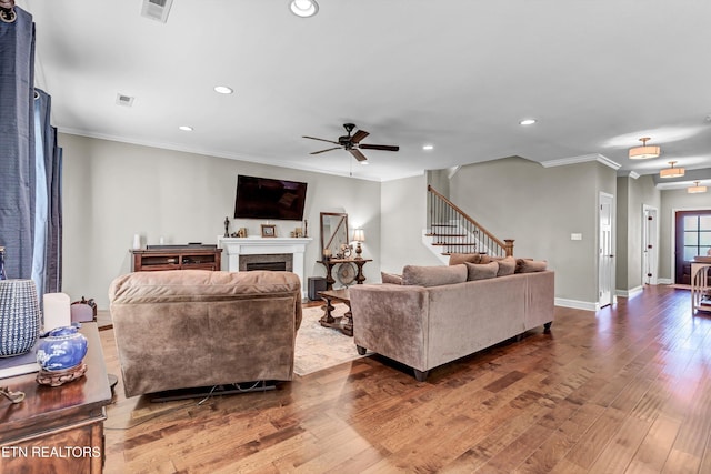 living room featuring visible vents, wood finished floors, baseboards, and ceiling fan