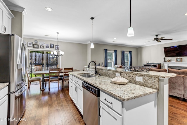 kitchen with dark wood-style floors, a sink, stainless steel appliances, crown molding, and open floor plan