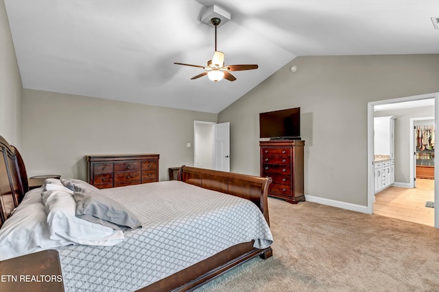 bedroom with ceiling fan, baseboards, light colored carpet, vaulted ceiling, and ensuite bathroom