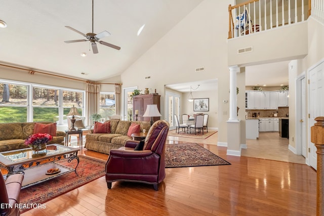 725 Wood Duck Dr, Vonore, TN 37885 - living room with decorative columns, high vaulted ceiling, a ceiling fan, light wood-type flooring, and baseboards