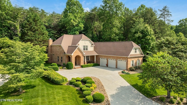 725 Wood Duck Dr, Vonore, TN 37885 - view of front of property with a garage, concrete driveway, a front lawn, brick siding, and a chimney
