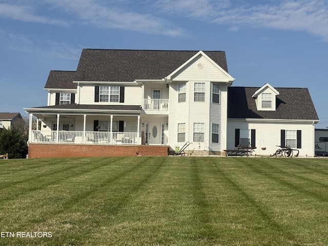 back of house with a lawn, a porch, and a balcony