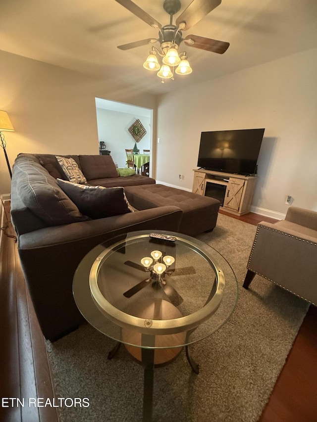 living room featuring baseboards and a ceiling fan