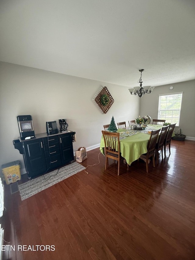 dining room with an inviting chandelier, dark wood-style flooring, and baseboards